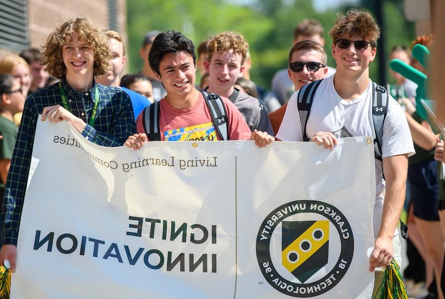 Male students marching with an Ignite banner